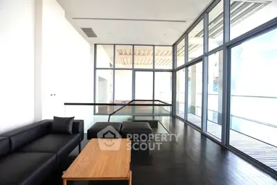 Luxurious modern living room with floor-to-ceiling windows and sleek black furniture.
