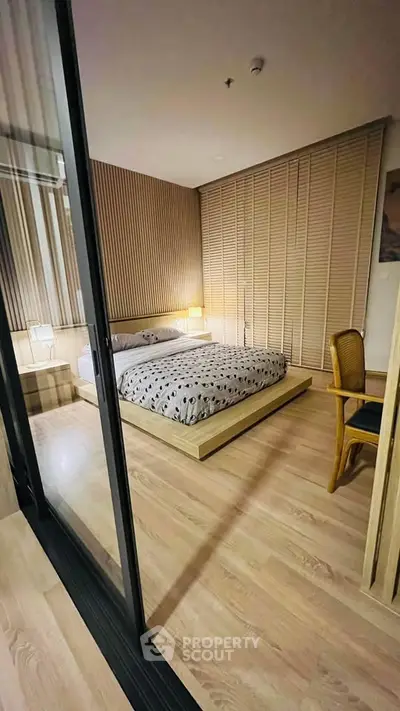 Modern bedroom with wooden flooring and stylish decor in a cozy apartment.