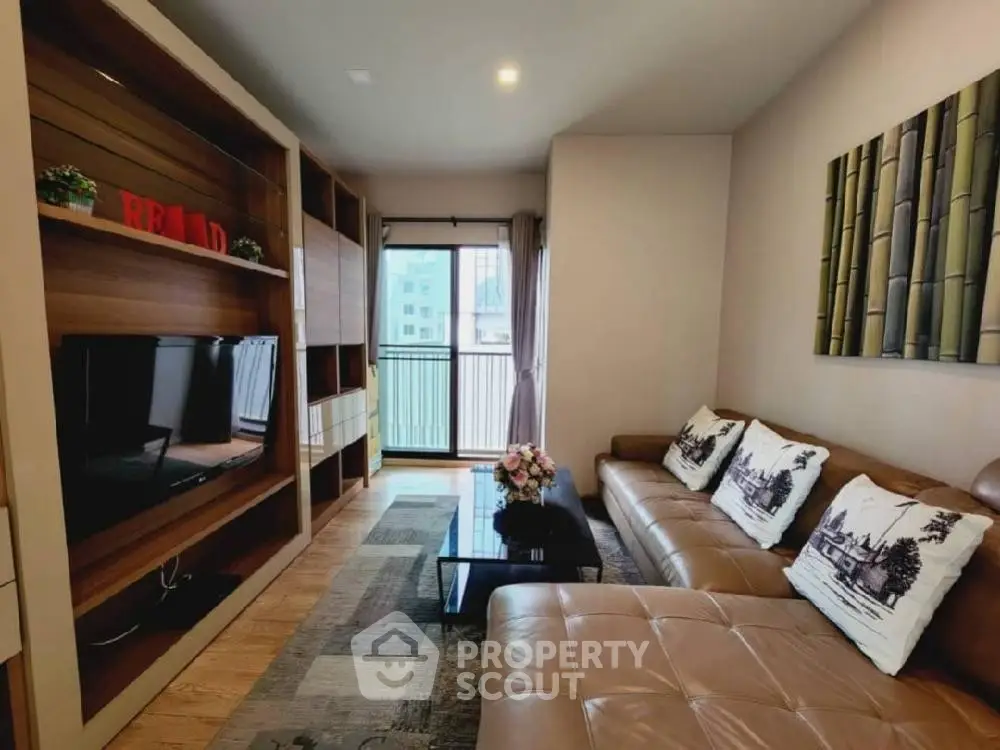 Modern living room with leather sofa and entertainment center, bright natural light.