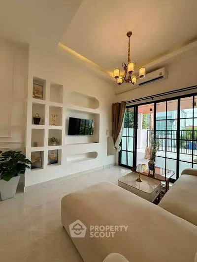 Elegant living room with modern decor and large windows opening to a balcony.