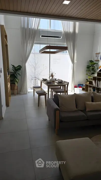 Modern living room with high ceiling and elegant dining area