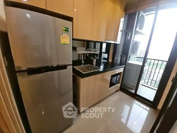 Modern kitchen with sleek cabinetry and stainless steel appliances in a high-rise apartment.