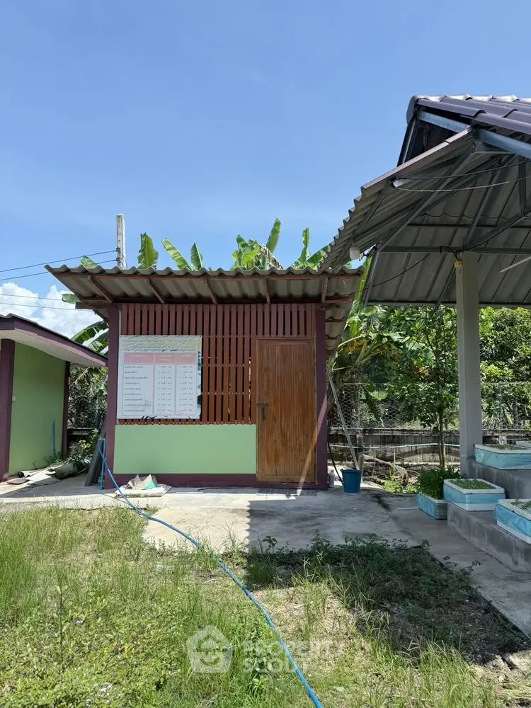 Charming small building with lush greenery and clear blue sky, perfect for serene living.