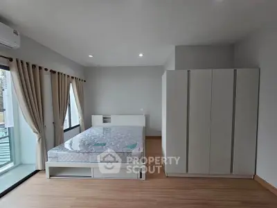 Spacious bedroom with modern decor and large windows for natural light