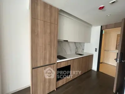 Modern kitchen with sleek wooden cabinetry and built-in appliances in a stylish apartment.