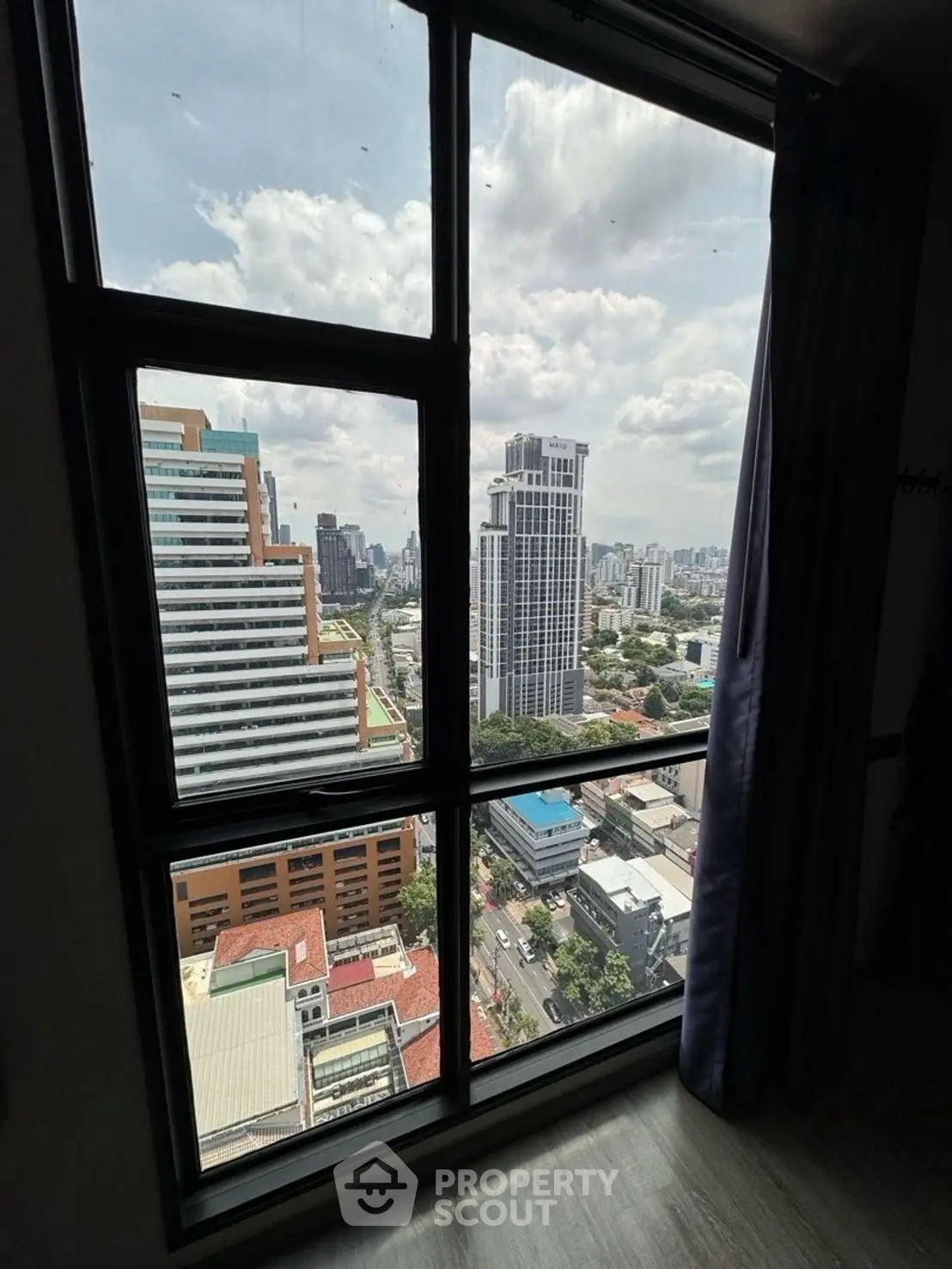 Stunning cityscape view from high-rise apartment window, showcasing urban skyline and vibrant city life.
