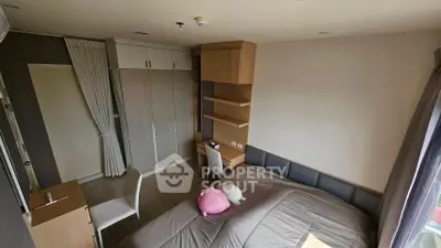 Cozy bedroom with modern furniture and ample natural light.