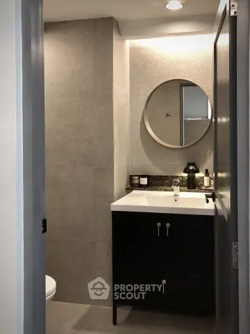 Modern bathroom with sleek vanity and round mirror, ideal for contemporary living.