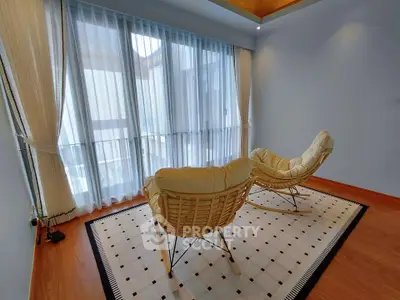 Stylish modern living room with cozy chairs and large windows