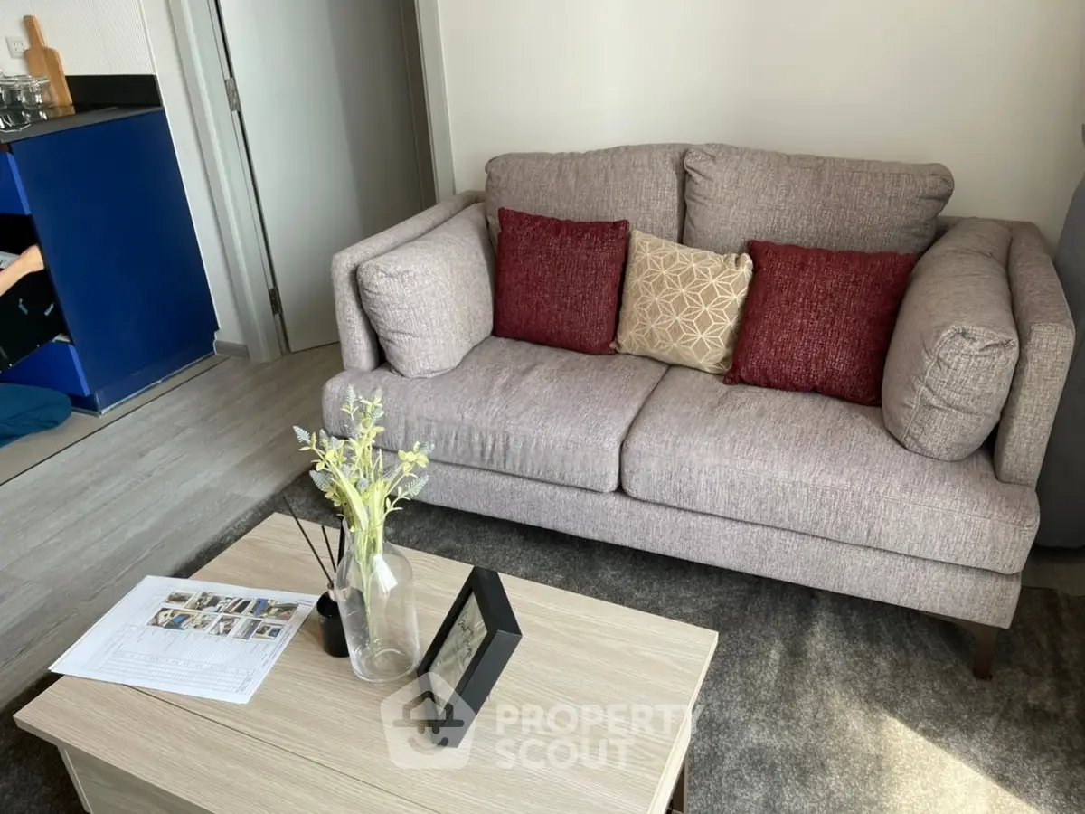 Cozy living room with stylish gray sofa and decorative pillows, complemented by a modern coffee table and elegant decor.