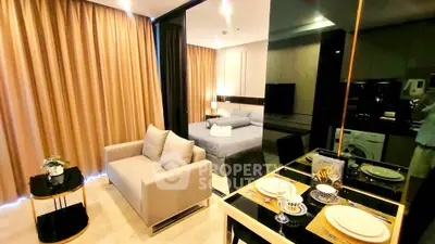 Modern studio apartment with cozy living area and elegant bedroom, featuring stylish decor and warm lighting.