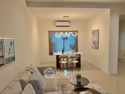 Modern living room with cozy sofa and elegant dining area, featuring contemporary lighting and stylish decor.