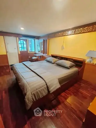 Spacious bedroom with elegant wooden flooring and cozy lighting