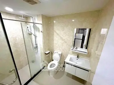 Modern bathroom with glass shower and sleek fixtures in a contemporary home.