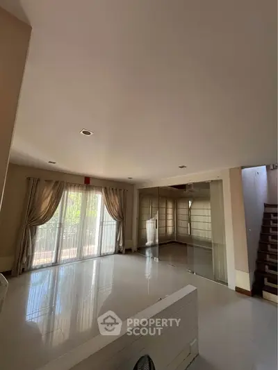 Spacious living room with large windows and elegant curtains