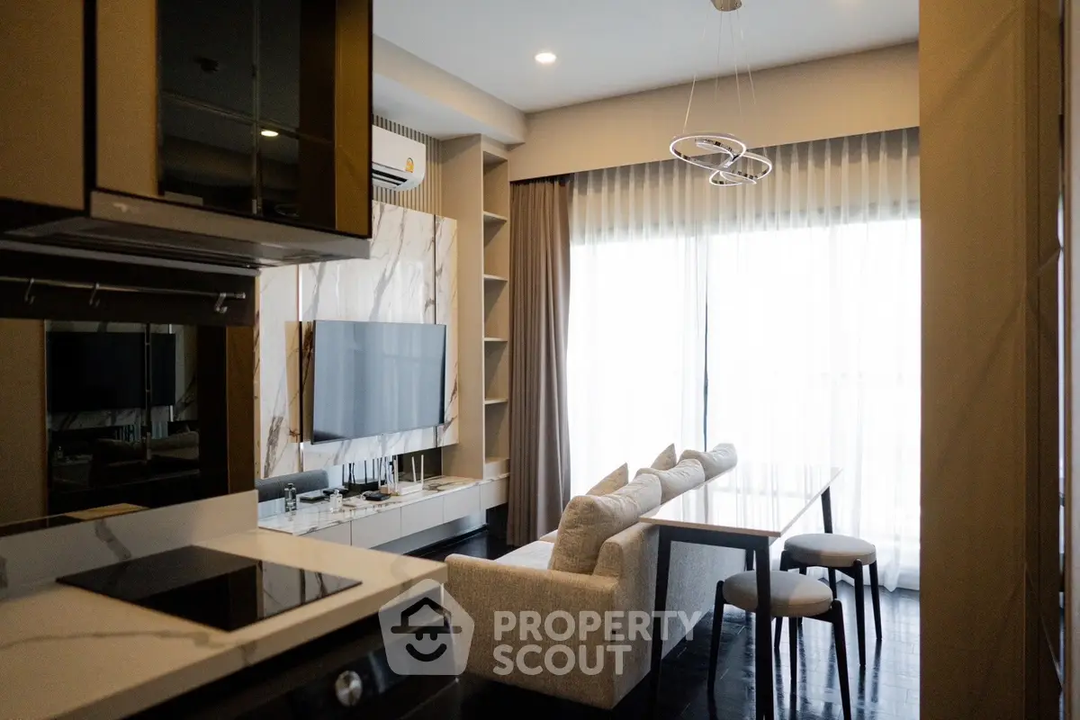 Modern living room with sleek kitchen, stylish decor, and large windows for natural light.