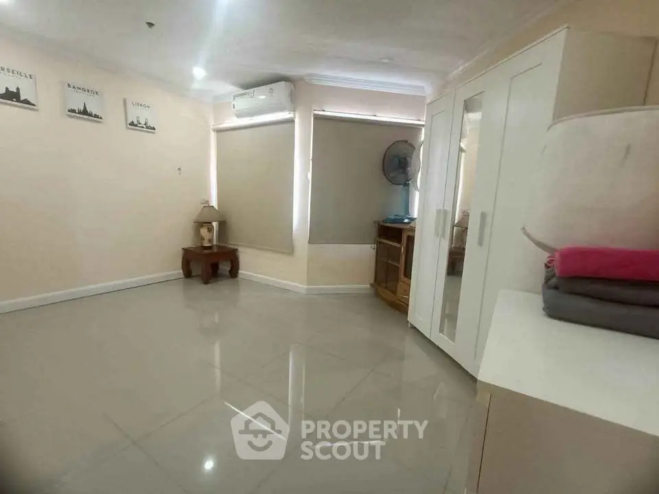 Spacious bedroom with modern wardrobe and air conditioning in a bright apartment.