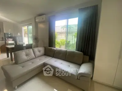 Spacious living room with modern L-shaped sofa and large window view