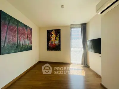 Bright living room with wooden flooring and artistic wall paintings