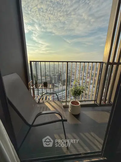 Stunning high-rise balcony with panoramic city view and cozy seating area.
