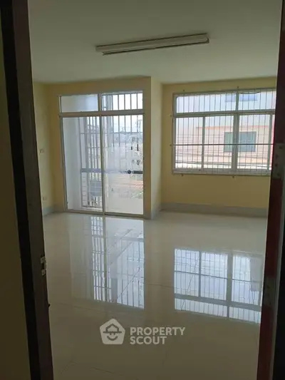 Spacious empty room with large windows and balcony access, perfect for customization.