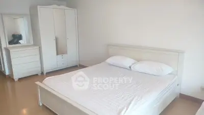 Spacious bedroom with white furniture and ample natural light