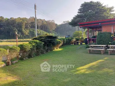Charming countryside property with lush garden and cozy outdoor seating area, perfect for relaxation.