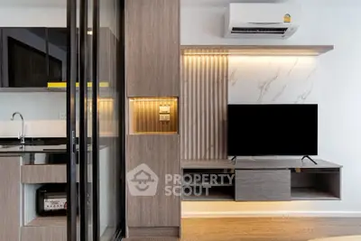 Modern living room with sleek kitchen, stylish cabinetry, and wall-mounted TV in a contemporary apartment.