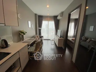 Modern apartment interior with open kitchen and cozy living area, featuring stylish decor and natural light.