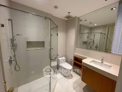 Modern bathroom with glass shower and sleek vanity in a contemporary home.
