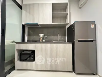 Modern compact kitchen with sleek cabinetry and stainless steel appliances
