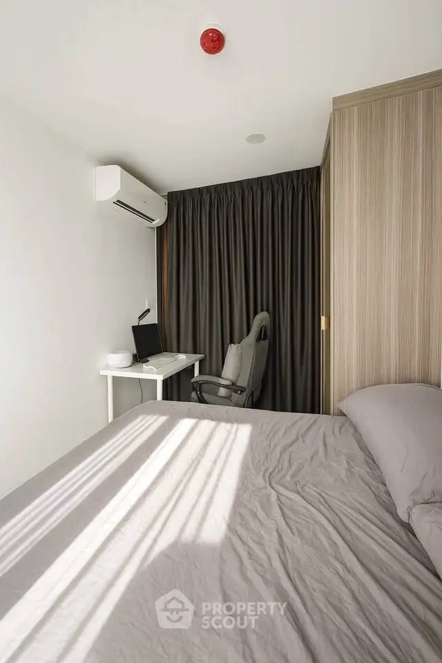 Cozy bedroom with modern decor, featuring a comfortable bed, study desk, and air conditioning.