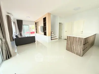 Spacious modern living room with open kitchen and sleek staircase design