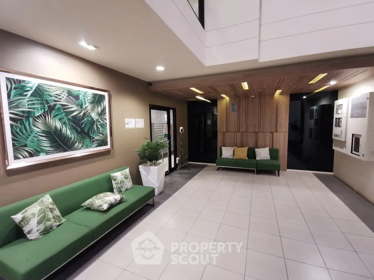 Modern apartment lobby with stylish green seating and tropical decor
