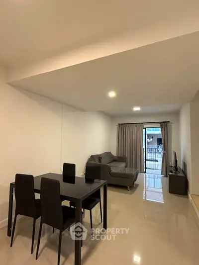 Modern living room with sleek furniture and balcony view