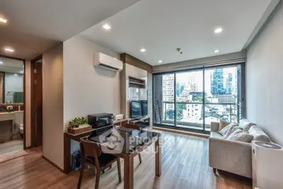 Modern living room with city view, featuring sleek furniture and large windows for natural light.
