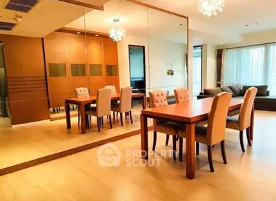 Spacious modern living room with elegant dining area and mirrored wall, perfect for entertaining.