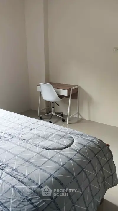 Cozy bedroom with modern desk and chair, perfect for a minimalist lifestyle.