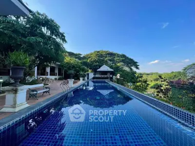 Luxurious outdoor pool with scenic garden view and elegant patio area.