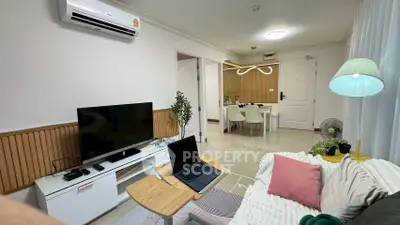 Modern living room with stylish decor and open dining area, featuring air conditioning and cozy seating.