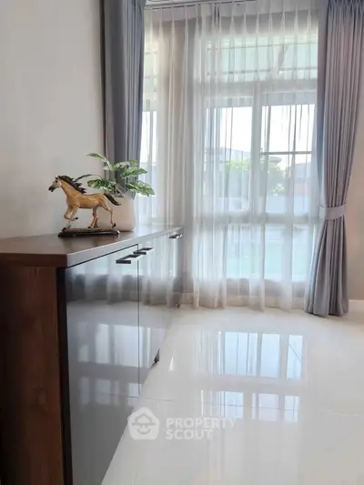 Bright and elegant living room corner with large windows and stylish decor
