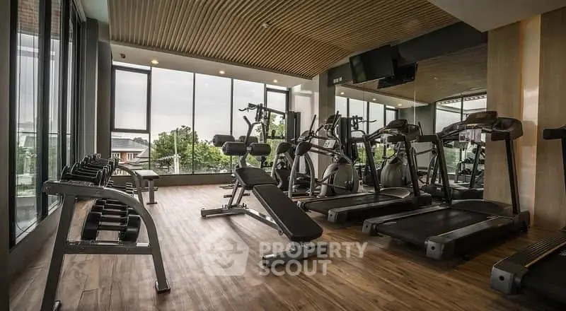 Modern gym with state-of-the-art equipment and large windows offering a scenic view.