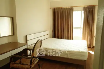 Cozy bedroom with natural light, featuring a comfortable bed and elegant wooden furniture.