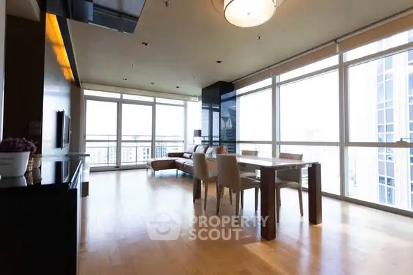 Spacious modern living room with large windows and elegant dining area