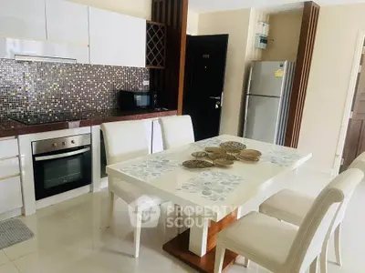 Modern kitchen with dining area, sleek appliances, and stylish mosaic backsplash.