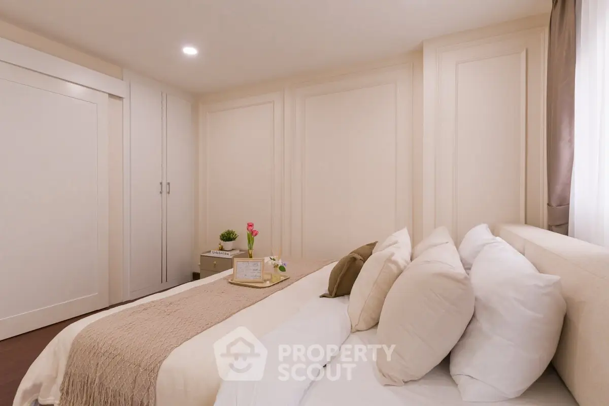 Elegant bedroom with cozy bedding and soft lighting, perfect for relaxation.