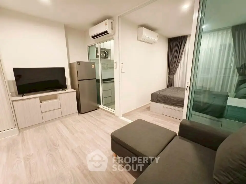 Modern studio apartment with sleek design and open layout, featuring a cozy living area and compact kitchen.