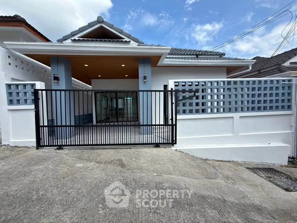 Charming single-story home with modern gate and spacious driveway, perfect for family living.