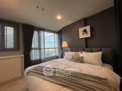 Luxurious bedroom with large window offering stunning city views, modern decor, and cozy ambiance.