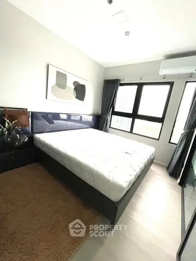 Modern bedroom with large windows and stylish decor in a high-rise apartment.